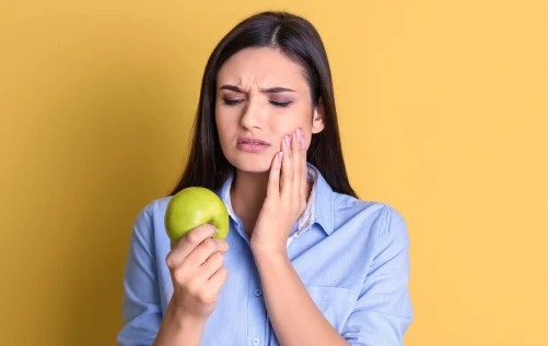 Woman holding apple and rubbing cheek