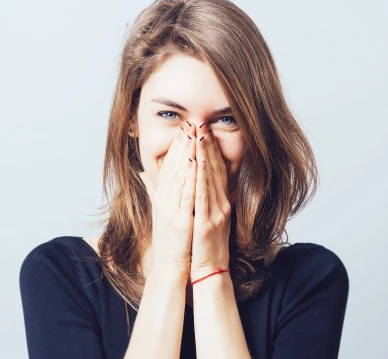 Woman Smiling with hands in front of her face